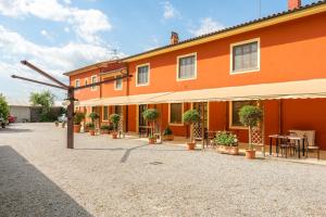 an orange building with potted plants in a courtyard at Casolare dei Fiori - Calla in Montecarlo