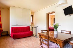 a living room with a red couch and a table at Casolare dei Fiori - Calla in Montecarlo