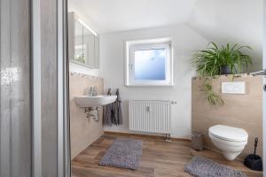 a bathroom with a sink and a toilet and a window at Ferienwohnung Örtzetal in Hermannsburg +15 photos