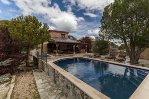 a swimming pool in front of a house at El Berrueco in El Berrueco