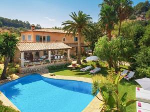 a villa with a swimming pool in front of a house at Font in Mancor del Valle