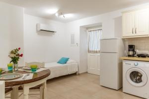 a kitchen and living room with a couch and a table at Afroditi Ftelia Yasemi b in Mykonos