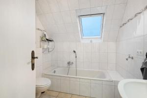 a bathroom with a tub and a toilet and a sink at Ferienwohnung Abendsonne in Lehe +15 photos