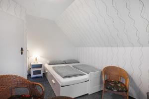 a small bedroom with a bed and two chairs at Ferienwohnung Abendsonne in Lehe