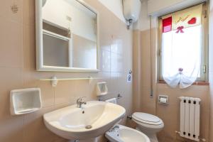 a bathroom with a sink and a toilet and a mirror at Residence Caravel 9 in Lido di Camaiore +11 photos