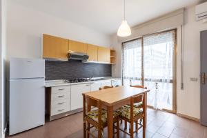 a kitchen with a wooden table and a white refrigerator at Residence Caravel 9 in Lido di Camaiore