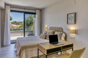 a bedroom with a bed and a desk with a laptop on it at Bonavista Begur in Begur +19 photos
