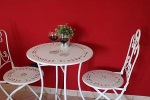 a table with two glasses of wine and two chairs at Relax and apartment in SantʼAgata Feltria +20 photos