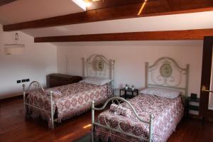two beds in a room with wooden floors at Relax and apartment in SantʼAgata Feltria