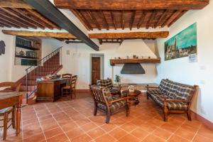 a living room with wooden ceilings and a staircase at Agriturismo la Taverna Di Celsa in Sovicille