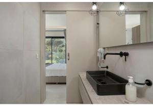 a bathroom with a sink and a mirror and a bed at Villa Zografia in Alikanas +36 photos