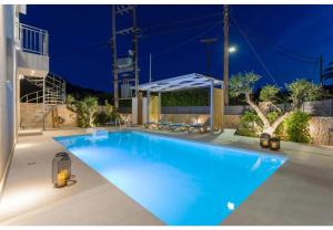 a large blue swimming pool at night at Villa Zografia in Alikanas