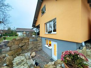 a house with a stone wall and a window at Carpe Diem in Altshausen
