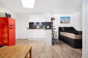 a kitchen with a red refrigerator next to a bed at Carpe Diem in Altshausen