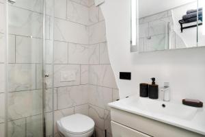 a white bathroom with a toilet and a shower at Carpe Diem in Altshausen