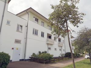 a white building with a tree in front of it at Ostseeperle Karlina in Karlshagen