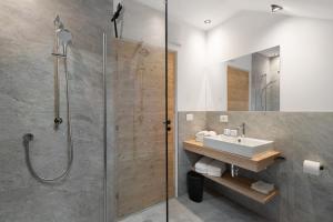 a bathroom with a glass shower and a sink at Pfaffingerhof Antholz in Masserie +45 photos