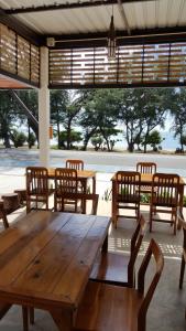 a wooden table and chairs in a room with a large window at Yellow House Rayong in Ban Phe