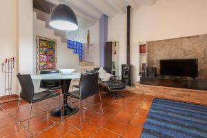 a living room with a table and chairs and a television at Maresme Natura in Sant Iscle de Vallalta
