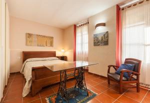 a bedroom with a bed and a desk and a table at Maresme Natura in Sant Iscle de Vallalta