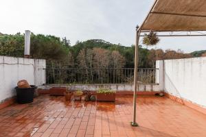 a balcony with potted plants on a brick floor at Maresme Natura in Sant Iscle de Vallalta