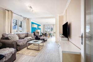 a living room with a couch and a tv at Ferienhaus Sandstrand in Timmendorfer Strand