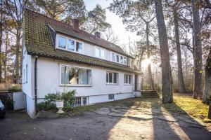 a white house with the sun shining through the trees at Ferienhaus Sandstrand in Timmendorfer Strand