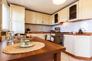 a kitchen with white cabinets and a wooden table at Appartamento Anita in Capoliveri