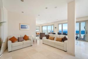 a living room with two white couches and the ocean at Stunning Casa Bella Vista in Adeje