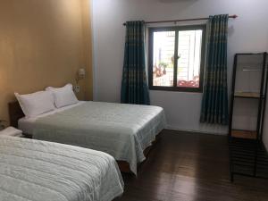 a hotel room with two beds and a window at Tam coc lotus lake homestay in Ninh Binh