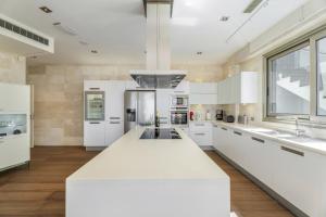 a kitchen with white cabinets and a large white island at Stunning Casa Bella Vista in Adeje