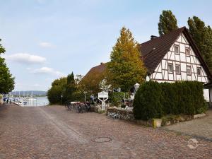 a house on the side of a river with a cobblestone street at Gästehaus Perlmuschel in Iznang