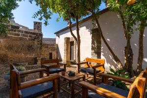 a group of chairs and a table and trees at Antica corte dell'800 in Castrignano del Capo