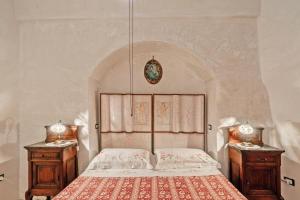 a bedroom with a large bed with two night stands at Antica corte dell'800 in Castrignano del Capo