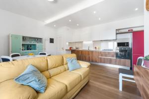 a living room with a couch and a kitchen at 4 Seasons Apartment in Guspini