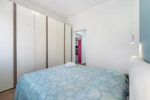 a bedroom with a blue bed in a white room at 4 Seasons Apartment in Guspini