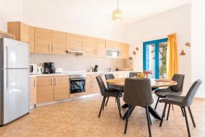 a kitchen with a table and chairs and a refrigerator at Villa Kalliope in Gennadi