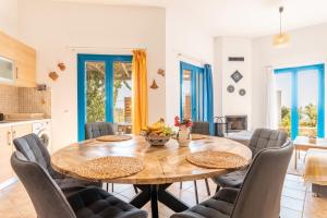 a kitchen and dining room with a wooden table and chairs at Villa Kalliope in Gennadi +22 photos