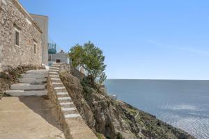a stairway leading up to a building on a cliff next to the ocean at Olympos Blue in Karpathos