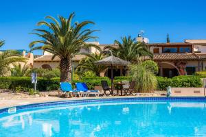 a swimming pool with chairs and a house in the background at Casa Arts 50 in Campos