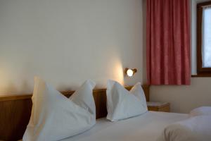 a bedroom with white pillows on a bed with a window at Apartment 1 - Zur Sonne in Laion