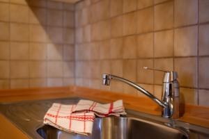 a kitchen sink with a red and white towel on it at Apartment 1 - Zur Sonne in Laion +11 photos
