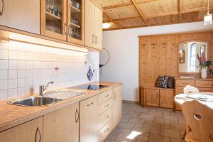 a kitchen with wooden cabinets and a sink at Schreiberhof Panorama in Laion +19 photos