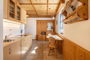 a kitchen with wooden cabinets and a table with a chair at Schreiberhof Panorama in Laion