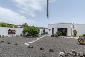 a courtyard with rocks and a white building at Guenia ll in El Mojón