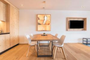 a dining room with a wooden table and chairs at Aura Chalets - Nr 1 in Castelrotto