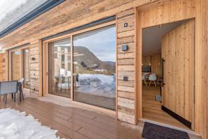 a wooden house with a large glass window at Aura Chalets - Nr 1 in Castelrotto