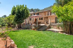 an old stone house with a lawn in front of it at Casa Caimari in Caimari