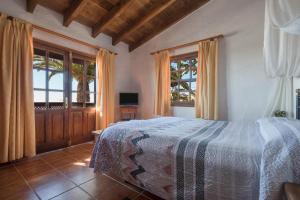 a bedroom with a bed and two windows at La Cuadra de Arona in Arona