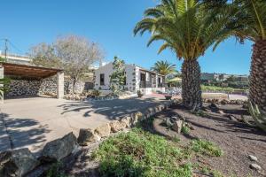 a street with palm trees and a building at La Cuadra de Arona in Arona